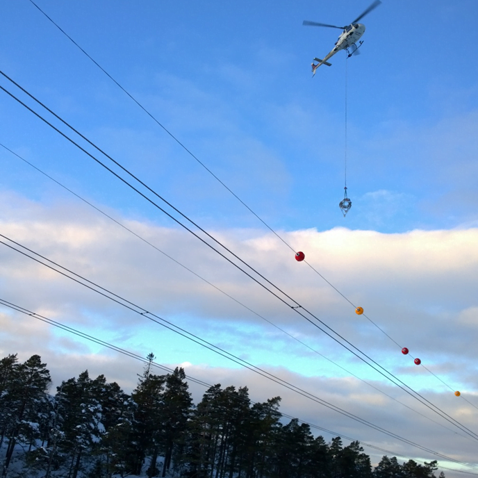 helicopter installing a air warming marker in a poweline